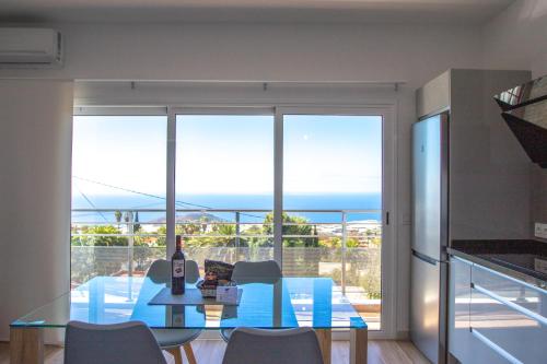 埃尔帕索Apartamentos Dos Palmas的一间设有玻璃桌的海景用餐室