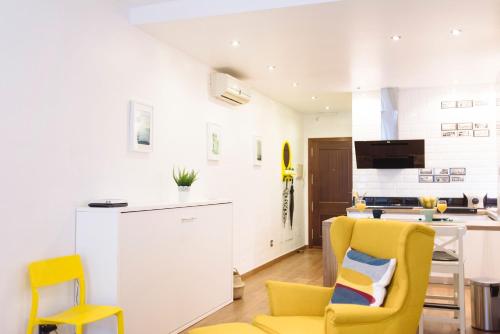 马拉加Blonski-Yellow的一间带黄色椅子的客厅和一间厨房