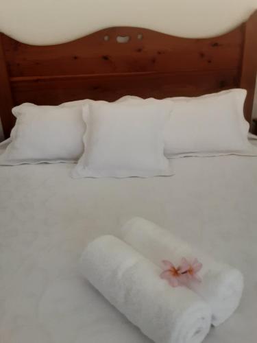 邦加里Banya Bliss - Guest House的一张带两条毛巾的白色床和一朵花