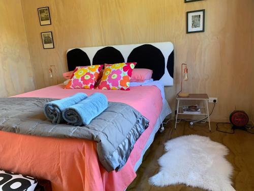 马斯特顿Fallow Hut的一间卧室配有一张带色彩缤纷枕头的大床