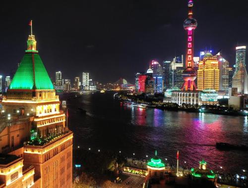 上海上海和平饭店的城市天际线,夜晚有河流和建筑