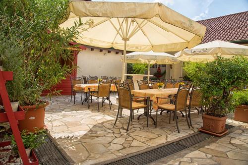 贝河畔的海尔斯伯格科朗酒店的一个带桌椅和遮阳伞的庭院