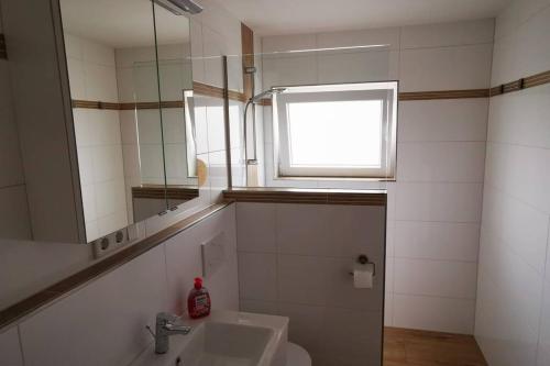 海罗德堡Willi´s Ferienwohnung的一间带水槽和镜子的浴室以及窗户。