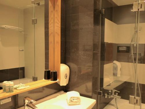 拉巴特Le Pietri Urban Hotel的带淋浴、水槽和镜子的浴室