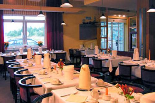 LankenTOP Motel Sassnitz的一间设有白色桌椅的用餐室