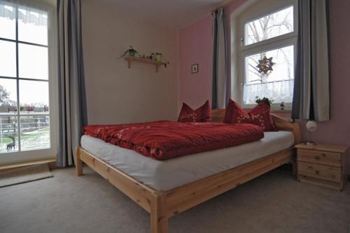 木尔森Landhaus Blumenstein的一间卧室配有一张带红色床单的床和一扇窗户。