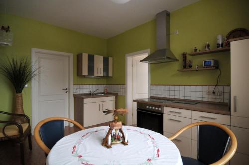 木尔森Landhaus Blumenstein的一间带桌子的厨房和一间带绿色墙壁的厨房