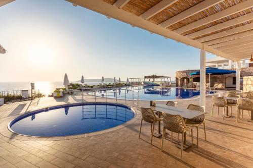 古穆斯卢克Vega Aparts的一个带游泳池和桌椅的度假酒店