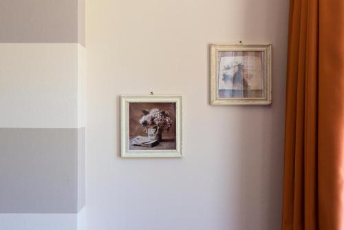梅扎纳Animae Natura Hotel & Chalet的两幅画在墙上,花瓶