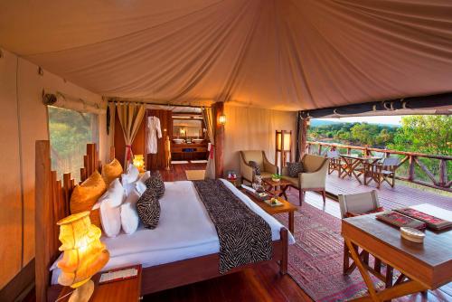 马赛马拉海王星马拉瑞安塔豪华营地全包酒店的帐篷内一间卧室,配有一张大床