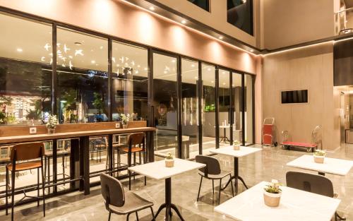 雅加达Stanley Wahid Hasyim Jakarta的餐厅设有桌椅和大窗户。