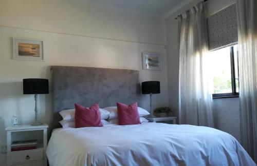 开普敦One Above的卧室配有带粉红色枕头的大型白色床