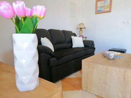 普特尼科维奇Holiday Home Blue Dream的客厅里白色花瓶,有粉红色的花朵