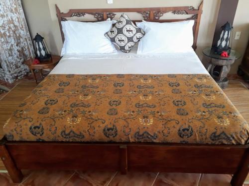 加罗帕巴Luxury Suites Vila Indonésia的一间卧室配有一张床、床罩和枕头