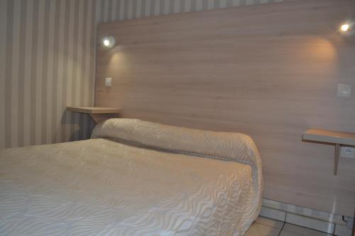 尼姆和睦酒店的一间卧室设有一张床和木墙