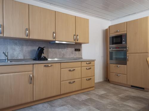 哈斯洛赫Top-Unterkunft in der Pfalz的厨房配有木制橱柜和炉灶烤箱。