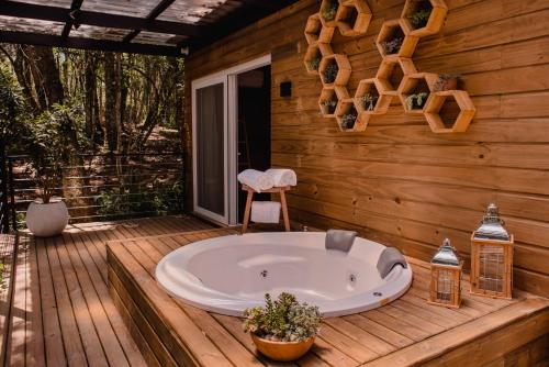 格拉玛多Vila Nambu - Exclusive Pousada的木房子甲板上的浴缸