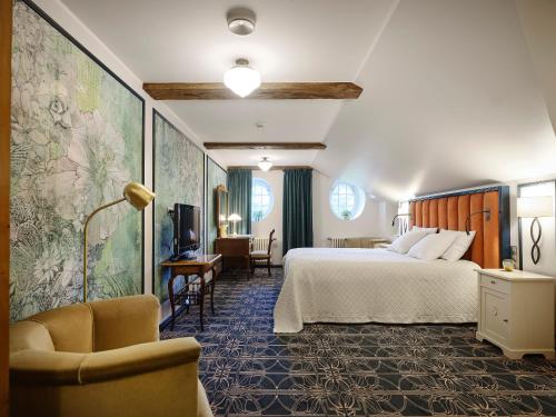 派尔努Villa Ammende Restaurant and Hotel的配有一张床和一把椅子的酒店客房