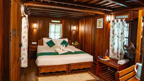 提喀迪Kalpavanam Heritage Resort的木制客房内的一间卧室,配有一张床