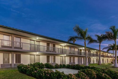 萨拉索塔Ramada by Wyndham Sarasota Waterfront的享有棕榈树建筑的外部景色