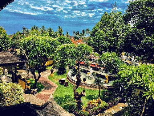 罗威那Bali Taman Lovina Resort & Spa Suites的享有公园美景,公园内拥有喷泉和树木