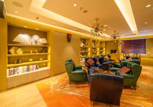 澳门澳门骏龍酒店的客厅设有绿色椅子和图书馆