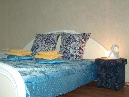 秋明Hotel Four Rooms on Energetikov的一张带蓝色和白色枕头的床和一盏灯
