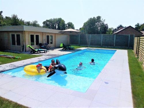 Gingelom曼霍夫公寓的一群人在游泳池玩耍