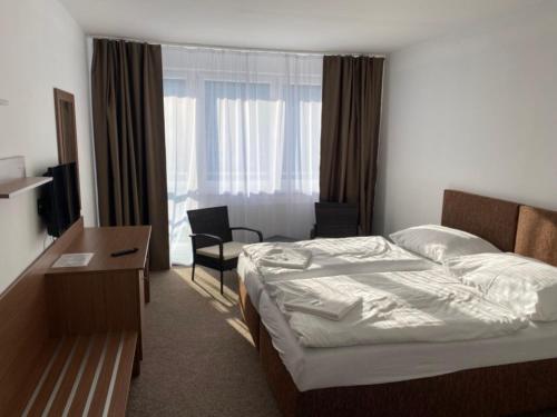 特普利采全景酒店的酒店客房设有一张床、一张书桌和窗户。