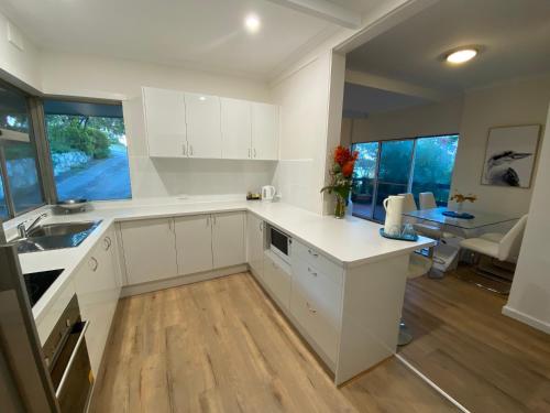 纳拉库特Panorama B&B的一间厨房,内设白色橱柜和一张桌子