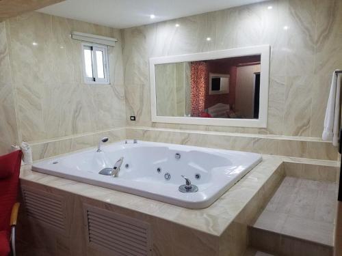 喀巴里特Kitewind Apartamentos Cabarete的一个带镜子的浴室内的白色大浴缸