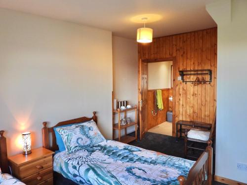 瑟索Windhaven Camping and B&B的卧室配有1张床、1张桌子和1把椅子