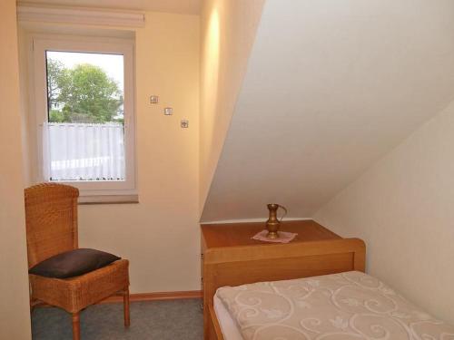施马伦贝格Ferienwohnung Hacke的卧室配有床、椅子和窗户。