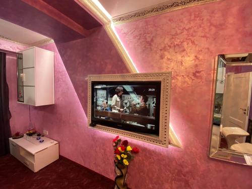 斯莫梁Стаи за гости Топ Старс Смолян的浴室设有粉红色墙壁上的电视