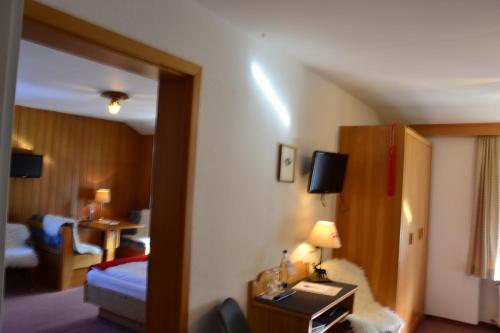 基姆湖畔贝尔瑙Hotel Jägerhof garni的酒店客房设有一间带一张床和一张桌子的卧室