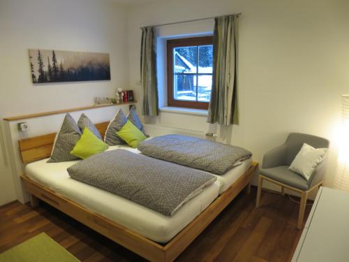 多内尔斯巴赫瓦尔德Ferienwohnung Mörsbachblick的一间卧室配有一张带椅子的床和一扇窗户