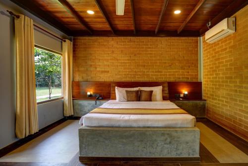锡吉里亚Kaveri Resort Sigiriya的卧室设有一张砖墙内的大床