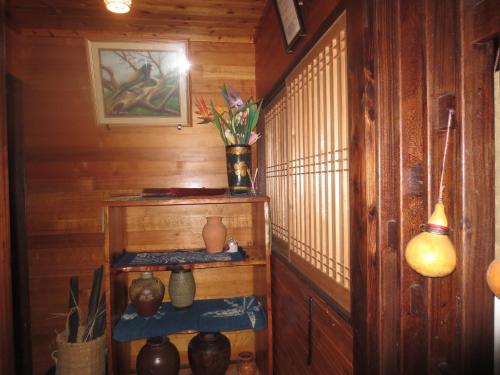 AkinaAmami skeptical inn - Vacation STAY 14029v的一间设有木墙和花瓶架的房间