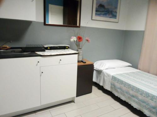 卡塞勒托瑞尼斯尼亚加拉酒店的一个带水槽的厨房和一张位于客房内的床