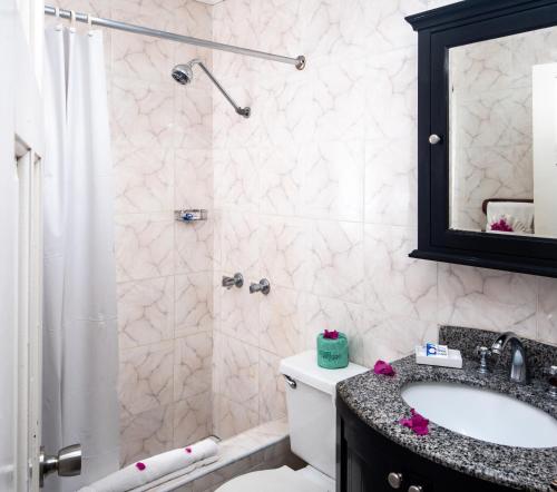 尼格瑞尔传奇海滩度假酒店的浴室配有卫生间、盥洗盆和淋浴。