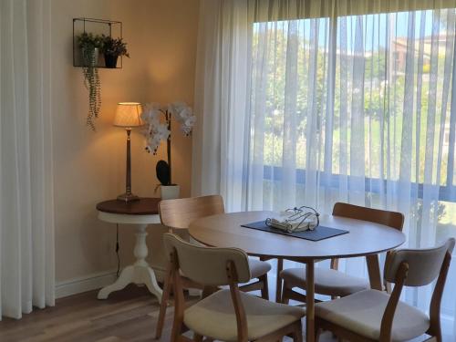 莱克斯恩特伦斯Abalone Guest Accommodation的一间带桌椅和窗户的用餐室