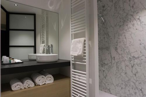 罗森达尔中心酒店的一间带水槽和淋浴的浴室