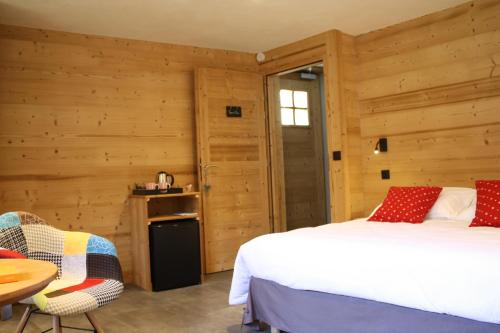 博福特Chalet du Bersend的一间卧室设有木墙、一张床和一张桌子