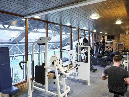 谢菲尔德Mercure Sheffield Kenwood Hall & Spa的一个带跑步机的健身房,有背景的人