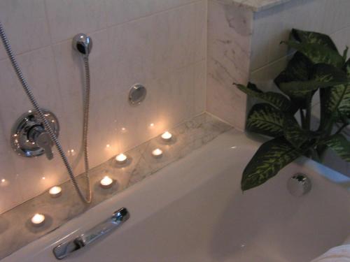 明登马贝拉餐厅酒店的浴室配有带灯的浴缸。