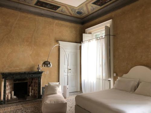 科莫阿布里奇佩雷利尼宫旅馆的一间卧室配有一张床和一个壁炉