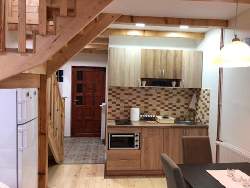 卡鲁德杰尔斯科巴尔Apartmani Sredojevic的厨房配有木制橱柜和白色冰箱。