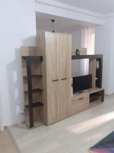 RoşuLuxury 1 Bedroom Apartment的带平面电视的木制娱乐中心