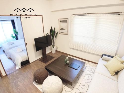 广岛OUCHI HOTEL Dambara的客厅配有沙发和桌子