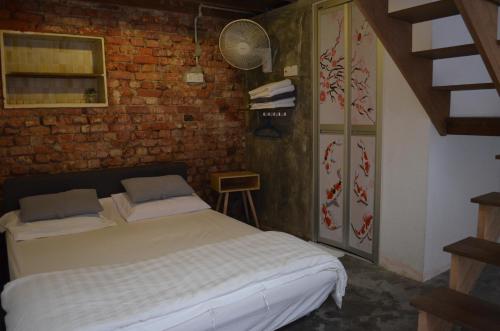 乔治市Dou Houz Georgetown的一间卧室设有一张床和砖墙